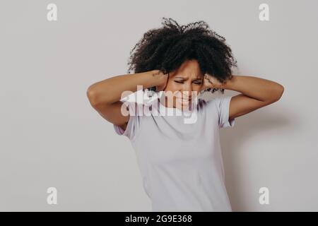 Une jeune femme en colère agacait une africaine qui couvrait ses oreilles des deux mains pour éviter le bruit fort Banque D'Images