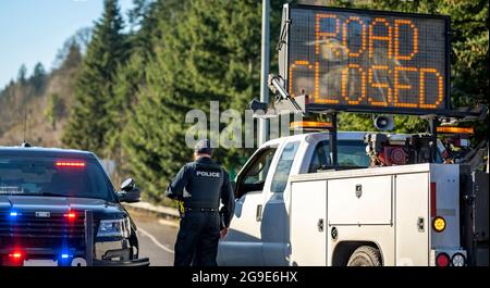 Officier de police en tenue et uniforme sur une voiture de police avec des feux clignotants et une voiture de service de route avec une carte électronique avec la route d'inscription est c Banque D'Images