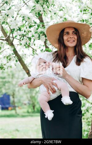 Joyeux souriant personnes de race blanche. Belle mère mignonne tenant son bébé. Jolie famille. Petite fille drôle avec femme attrayante. Ver Banque D'Images