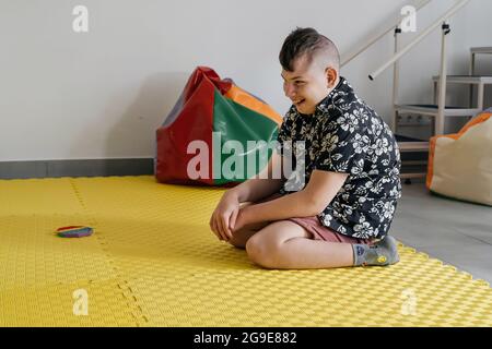 Les enfants ayant un handicap se font une activité sensorielle avec des jouets, des balles, des petits objets, un garçon souffrant de paralysie cérébrale jouant à un jeu apaisant, s'entraîner à de fines aptitudes motrices Banque D'Images