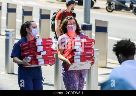 Londres, Royaume-Uni. 18 juillet 2021. Les femmes portant des masques portent des boîtes de Domino's Pizza à Londres. Crédit : SOPA Images Limited/Alamy Live News Banque D'Images