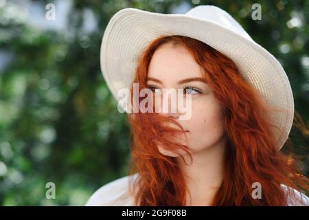 Portrait en gros plan de la jeune femme avec un chapeau à l'extérieur en ville, photo. Banque D'Images