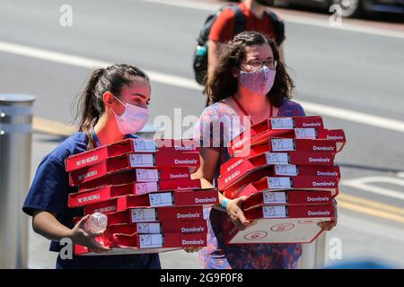 Londres, Royaume-Uni. 18 juillet 2021. Les femmes portant des masques portent des boîtes de Domino's Pizza à Londres. (Photo de Dinendra Haria/SOPA Images/Sipa USA) crédit: SIPA USA/Alay Live News Banque D'Images
