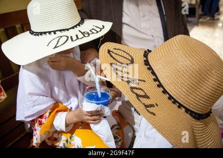 Deux jeunes fashionistas portant des chapeaux de Dubaï pendant leurs vacances aux Émirats Arabes Unis. Banque D'Images