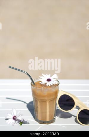 Café glacé Cyprus Frappe Fredo vue de dessus sur table blanche, avec lunettes de soleil. Arrière-plan, vacances ou concept de vacances minimalistes d'été. Soleil et ombres. Banque D'Images