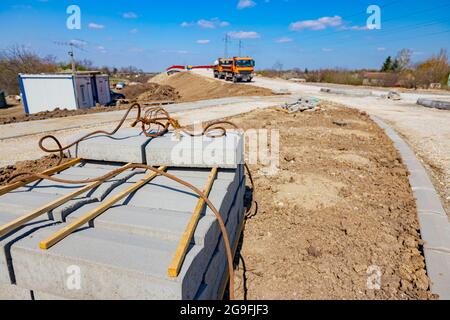 Pile de pierres de bordure emballées pour la route asphaltée sur palette en bois sur le chantier de construction. Banque D'Images