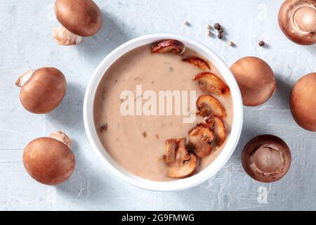 Soupe à la crème de champignons, prise par le dessus avec des champignons portobello et du poivre sur une table Banque D'Images