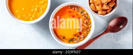 Panorama de la soupe végétalienne, plan de pose à plat au-dessus. Purées de crème de citrouille et de maïs, régime alimentaire sain de détox végétalien Banque D'Images