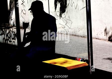 Vieil homme avec béquille à l'arrêt de bus, Barcelone, Espagne. Banque D'Images