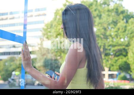 Portrait d'une jeune femme latine attendant le bus à un arrêt de bus dans la rue. Banque D'Images