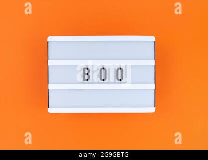 Boîte lumineuse avec mot Boo sur fond orange. Banque D'Images