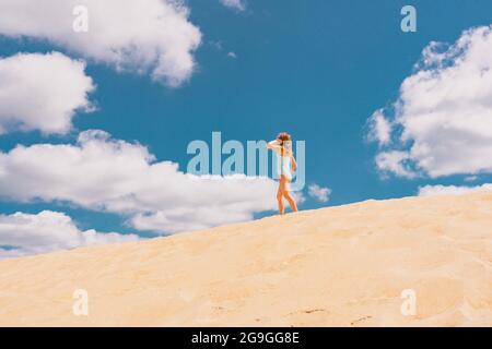 Photo de vue aérienne - une fille solitaire marche sur le désert de sable. Photo de haute qualité Banque D'Images