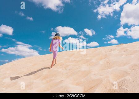 Photo de vue aérienne - une fille solitaire marche sur le désert de sable. Photo de haute qualité Banque D'Images