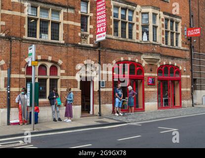 Les gens attendent à un arrêt de bus devant les arts au centre artistique Old Fire Station à George Street, Oxford, Angleterre, Royaume-Uni Banque D'Images