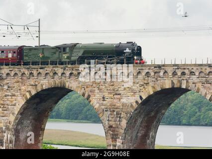 La machine à vapeur Tornado de classe A1 et les voitures anciennes se déplacent au-dessus du viaduc ferroviaire construit par Robert Stevenson à Berwick-upon-Tweed Banque D'Images