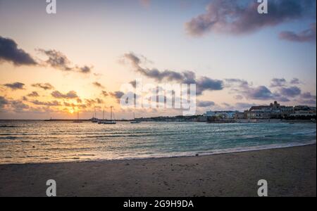 Magnifique lever de soleil sur la plage dans la baie de la ville d'Otrante, Apulia, Mer Adriatique, Salento, Italie. Personne. Couleurs dorées douces, ciel nuageux. Matin d'été en Italie. Banque D'Images