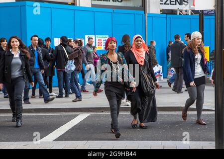 Londres, Royaume-Uni - 2019 novembre, les gens traversent la rue à l'heure de pointe sur Oxford Street, la principale rue commerçante. Banque D'Images