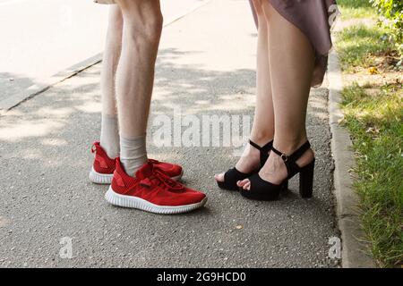 jambes d'un homme et d'une femme face à face. debout sur le trottoir le jour de l'été Banque D'Images