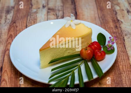 Vue panoramique sur le gâteau au fromage sur une petite assiette blanche décorée de baies rouges. Banque D'Images