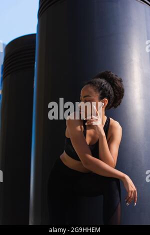 African american sportswoman dans les écouteurs et en plein air Banque D'Images
