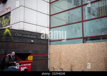 Bristol, Royaume-Uni. 22 mars 2021. Le matin après que Bristol ait été témoin de sa pire violence dans la rue pendant plusieurs années, le processus de nettoyage commence par le nettoyage des graffitis et le balayage des débris. Des manifestants ont attaqué hier la police après que des milliers de personnes aient assisté à une manifestation selon laquelle les officiers avaient « fortement conseillé » de ne pas se joindre à eux. Les policiers ont subi des fractures et les véhicules de police ont été mis à feu alors que des scènes de colère se déroulaient dans le centre-ville de Bristol. Photo : des fenêtres écrasées du poste de police de Bridewell sont visibles depuis la rue après l'émeute d'hier soir. Banque D'Images