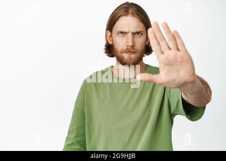 Gros plan portrait d'un homme barbu sérieux se prolongeant la main, frognant le bouleversement dire d'arrêter, d'interdire ou d'interdire smth, rester non, mécontent par smth, debout Banque D'Images