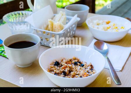 Gros plan d'une table de petit déjeuner joliment agencé avec café, sandwichs et porridge sur la terrasse Banque D'Images
