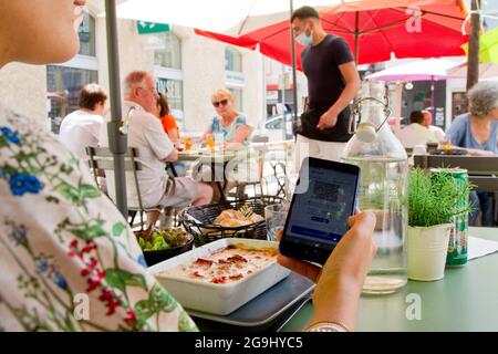 Depuis juillet 21, le passe Santé est requis pour accéder à des lieux de loisirs et culturels pouvant accueillir au moins 50 personnes. Dès le début du mois d'août, il devrait devenir obligatoire dans les cafés, les bars, les restaurants, les centres commerciaux, les maisons de retraite et les transports longue distance, ici illustration de la passe sanitaire dans un restaurant. France le 26 juillet 2021. Photo de Durand Thibaut/ABACAPRESS.COM Banque D'Images