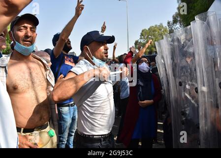 Tunis, Tunisie. 26 juillet 2021. Des policiers tunisiens empêchent les manifestants d'avancer vers le Parlement pendant la manifestation.le président tunisien Kais Saied a annoncé la suspension du Parlement du pays et la révocation du Premier ministre Hichem Mechichi après une journée de protestations contre le parti au pouvoir. Crédit : SOPA Images Limited/Alamy Live News Banque D'Images