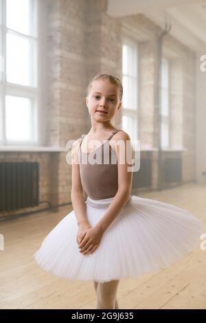 Portrait de la petite danseuse de ballet en robe tutu regardant caméra debout à l'école de danse Banque D'Images