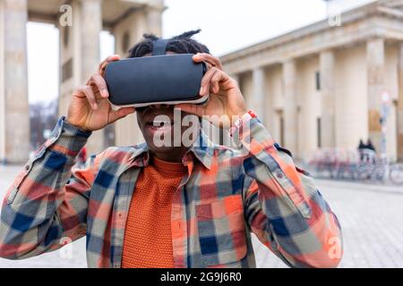 Allemagne, Berlin, homme utilisant des lunettes de réalité virtuelle dans la ville Banque D'Images