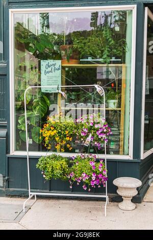 Colfax, Washington, États-Unis. 22 mai 2021. Paniers de fleurs suspendus à l'extérieur d'un fleuriste de petite ville. Banque D'Images