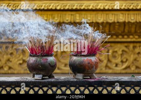 Pots décorés de bâtonnets d'encens dans un temple bouddhiste de Bago, au Myanmar Banque D'Images