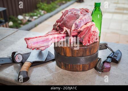 Viande crue sur une terrasse pour faire le déjeuner. Viande fraîche sur une planche à découper avec de l'huile d'olive et un couteau. Gros plan. Banque D'Images
