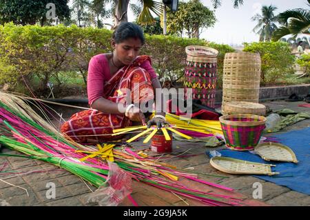KOLKATA, BENGALE-OCCIDENTAL , INDE - DÉCEMBRE 14th 2013 : Femme non identifiée faisant des paniers en osier , artisanat exposé à la foire de l'artisanat à Kolkata. Banque D'Images
