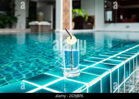 Un verre d'eau fraîche au bord de la piscine. Banque D'Images