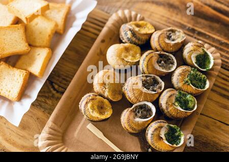 Helix aspersa Muller, escargot Maxima. Escargots comestibles avec beurre et assaisonnements. Banque D'Images