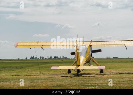 Avion jaune vintage sur l'aérodrome attendant d'aller dans la vue aérienne de l'arrière. Des avions légers à haut rendement à moteur unique sont disposés de manière conventionnelle Banque D'Images