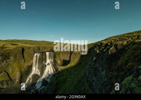 Pistes d'étoiles, chute d'eau Fagrifoss, rivière Geirlandsa, région de Lakagigar, parc national de Vatnajoekull, Highlands, Islande Banque D'Images