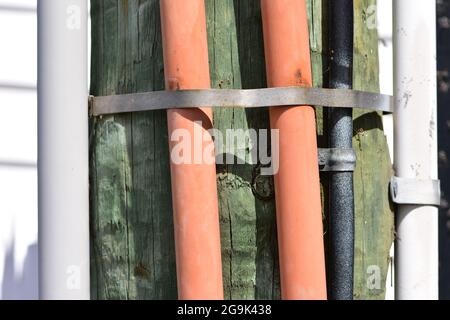 Détail de la grille électrique avec des câbles dans des tubes en plastique maintenus par des colliers métalliques. Banque D'Images