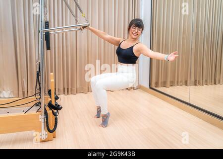 Jeune femme asiatique travaillant sur la machine de reformage de pilates pendant son entraînement de dexercise de santé Banque D'Images