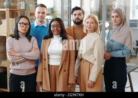 Grand groupe de responsables d'heures multiraciaux confiants dans les tenues de formalport debout dans la rangée Banque D'Images