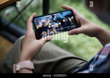 Pendant la mise en quarantaine d'une femme regardant la diffusion en direct par application sur un smartphone. Banque D'Images