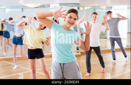 Une adolescente s'exerçant pendant un cours de danse de groupe Banque D'Images