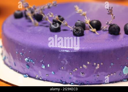 Délicieux gâteau aux myrtilles décoré de baies fraîches bleu noir, de perles, de branches de fleurs de lavande de près. Gâteau d'anniversaire appétissant. Savoureux myrtille c Banque D'Images