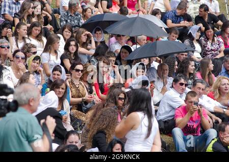 Lepushe, Albanie - 11 août 2012 : la foule assemblée siège au 'Highlanders Festival 2012' (albanais : Logu i Bjeshkëve) certaines personnes protègent le thème Banque D'Images