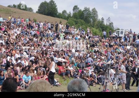 Lepushe, Albanie - 11 août 2012 : la foule assemblée siège au 'Highlanders Festival 2012' (albanais : Logu i Bjeshkëve) certaines personnes protègent le thème Banque D'Images