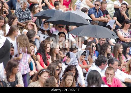 Lepushe, Albanie - 11 août 2012 : la foule assemblée siège au 'Highlanders Festival 2012' (albanais : Logu i Bjeshkëve) certaines personnes protègent le thème Banque D'Images