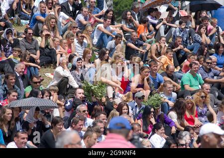 Lepushe, Albanie - 11 août 2012 : la foule assemblée siège au 'Highlanders Festival 2012' (albanais : Logu i Bjeshkëve) certaines personnes protègent le thème Banque D'Images