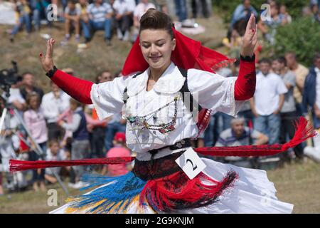 Lepushe, Albanie - 11 août 2012 : jolie fille danse avec les habillés en albanais traditionnel au son de la musique traditionnelle et participe Banque D'Images